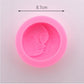 Pink silicone face mold with embossed smiling baby face relief inside.