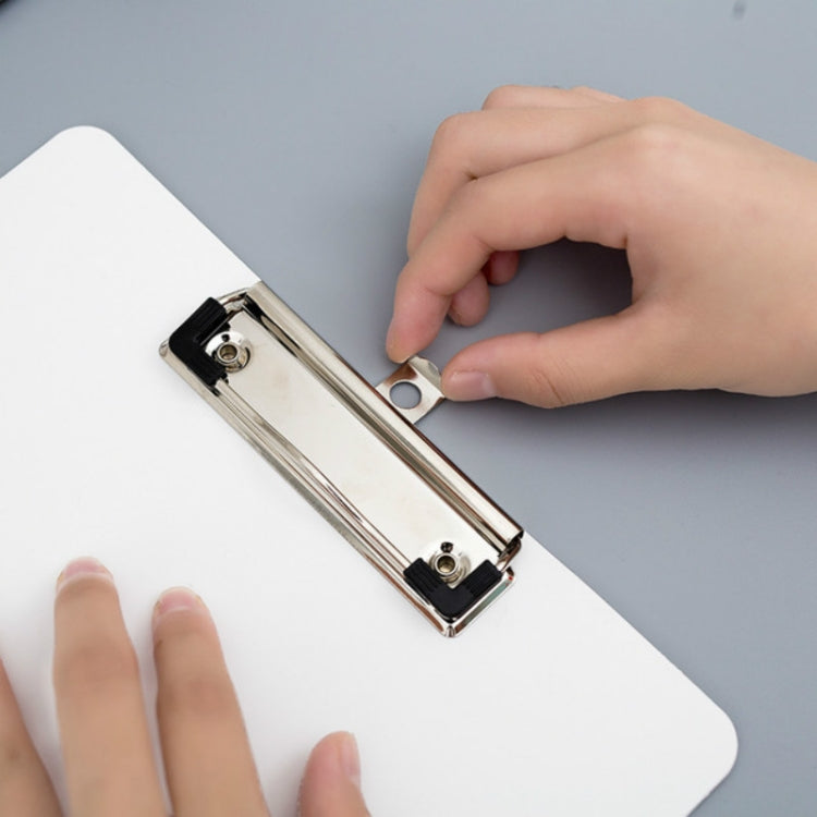 White clipboard with metal clip, close-up of a hand adjusting the paper.