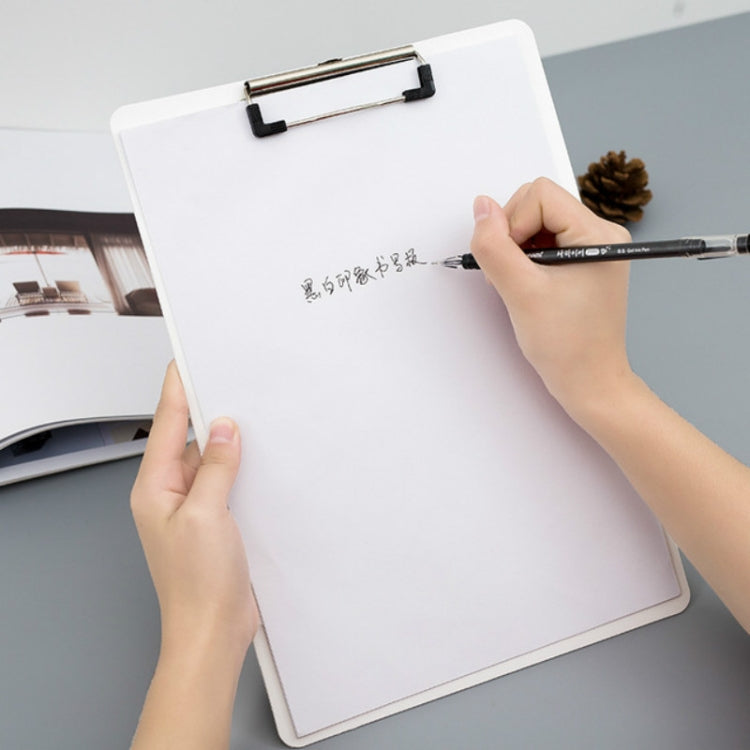 White clipboard with metal clip and hand writing on the paper.