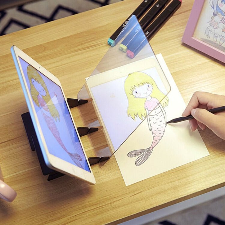 Optical tracing board holding two tablets while drawing a cartoon mermaid
