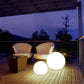 LED globe floor lamp with two round white lights on an outdoor patio at dusk