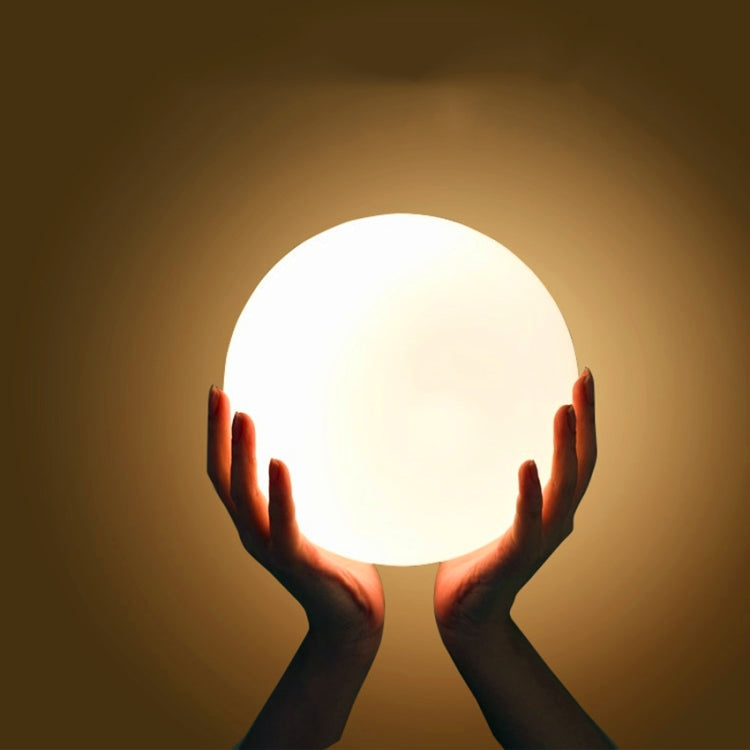 Round LED globe lamp held in hands with bright white illumination