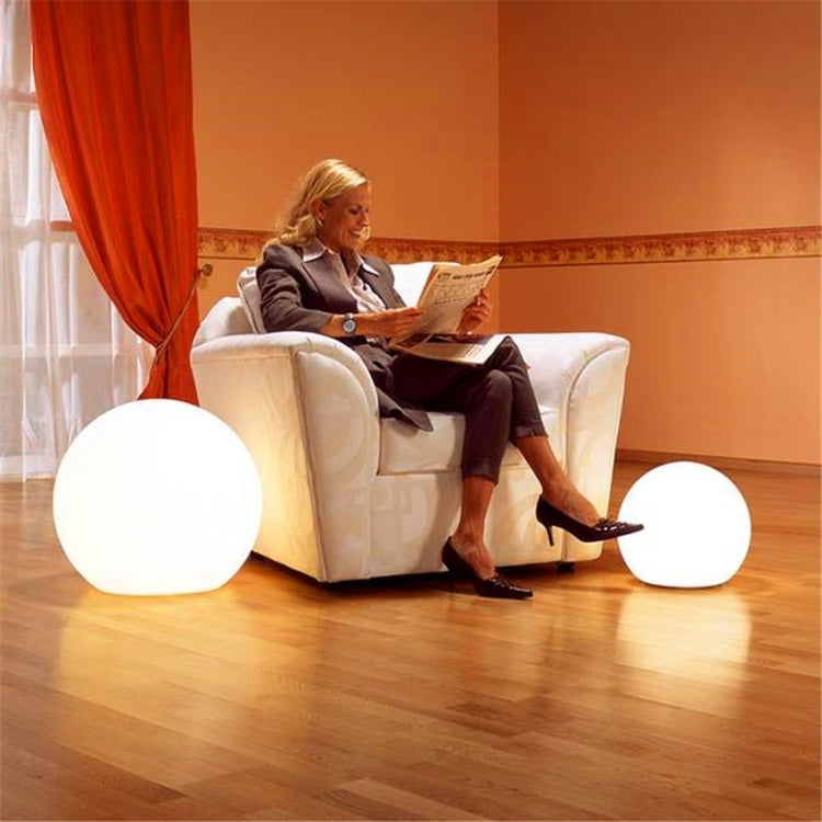 LED globe floor lamp with two round white lights beside a sofa