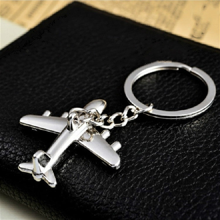 Silver airplane keychain with split-ring and attached chain, viewed from above