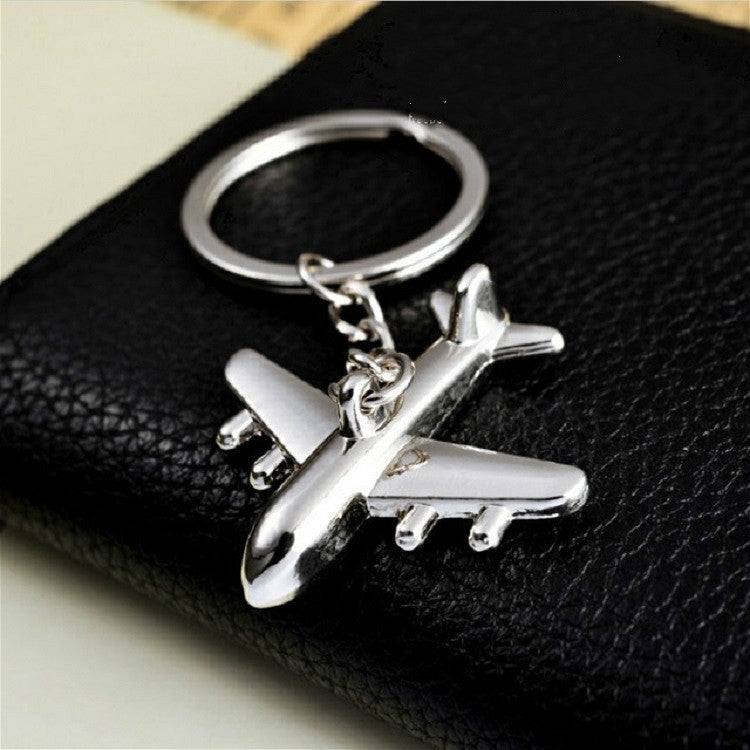 Silver airplane keychain pendant with split-ring and chain, close-up