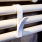 White plastic towel rack hook with curved holder on a bathroom rail