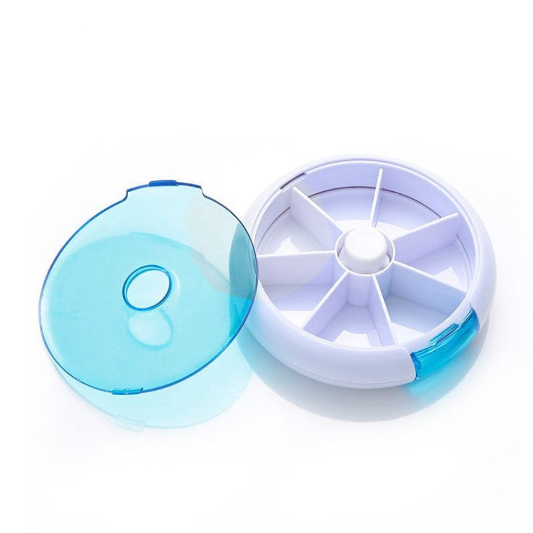 Blue and white rotating plastic pill box with seven grid compartments, lid open