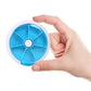 Blue and white rotating plastic pill box with seven grid compartments, lid being opened