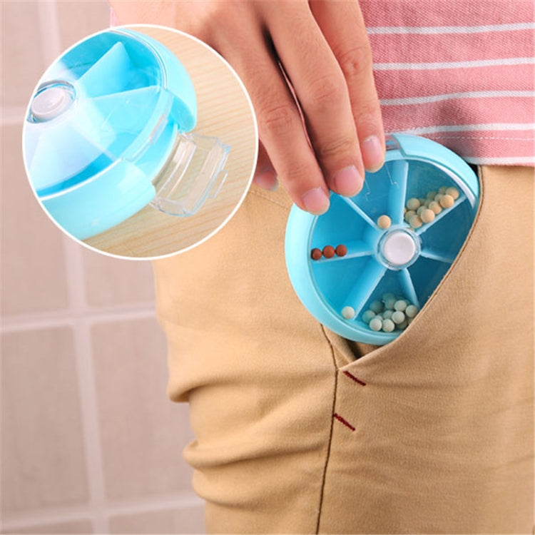 Blue rotating plastic pill box with seven grid compartments, one compartment filled