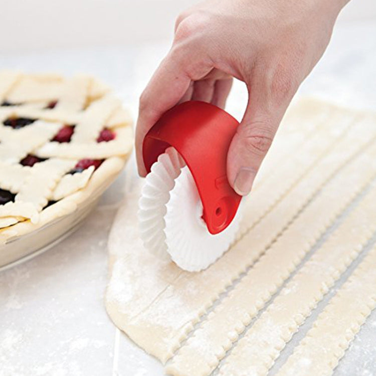 Red pasta cutting wheel tool with white ridged roller for slicing dough strips