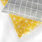 Corner close-up of gray grid and yellow geometric pet sleeping mat