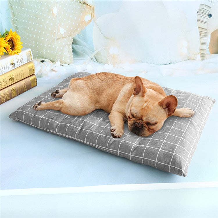 Gray grid pet sleeping mat with tan dog lying curled up