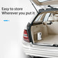 White portable tire air pump stored in car trunk beside open door
