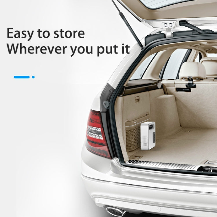 White portable tire air pump stored in car trunk beside open door