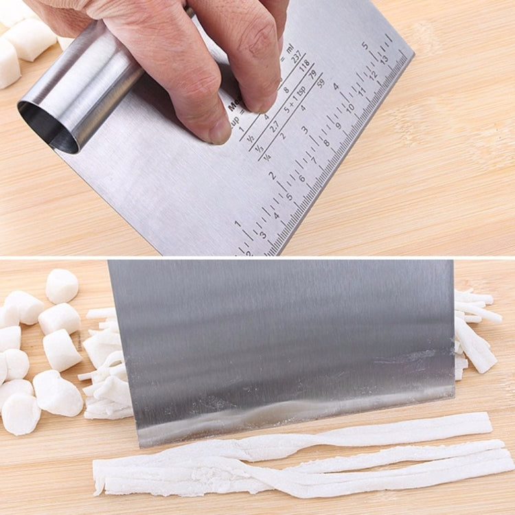 Stainless steel noodle cutter roller with measuring scale, held over sheet