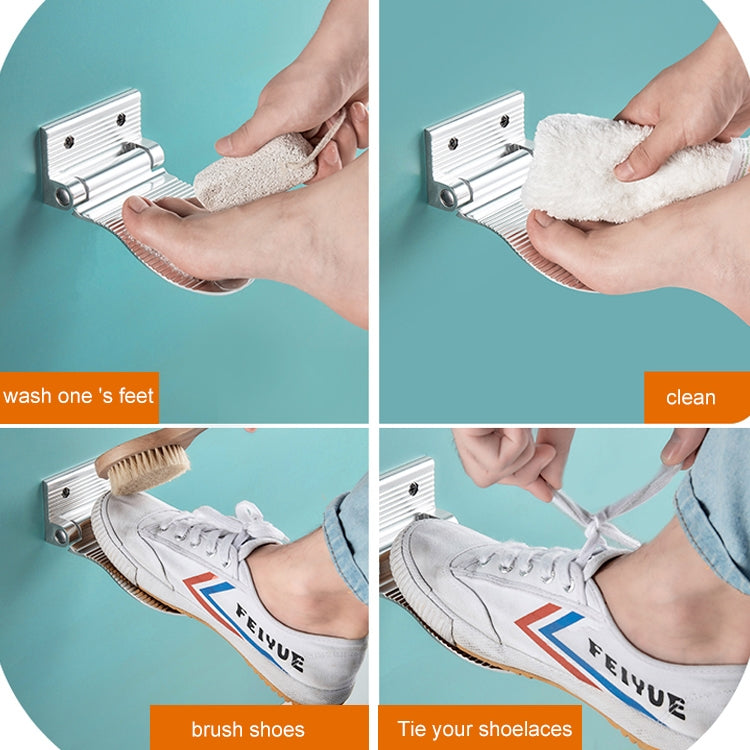 Silver wall-mounted shower foot rest being wiped clean with a cloth