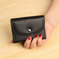 Black pebbled leather card wallet with front flap and metal snap button