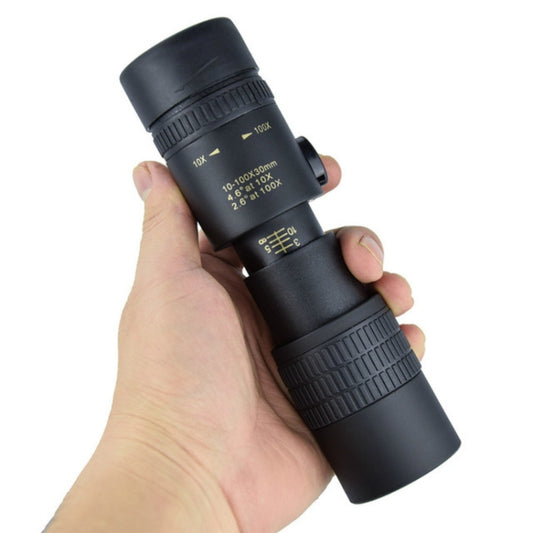 Black night vision monocular held in hand, showing zoom scale and knobs