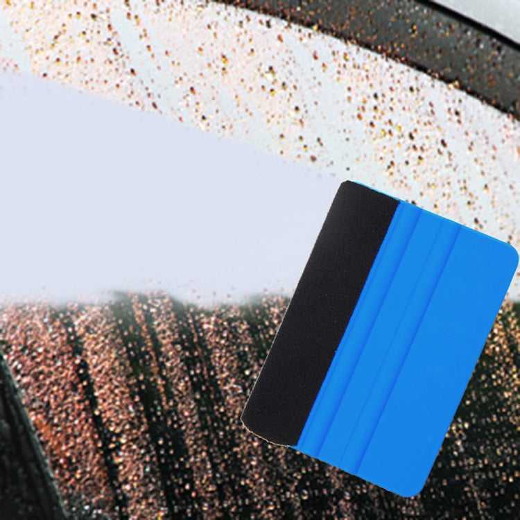 Blue felt scraper tool with black pad, positioned on car window surface