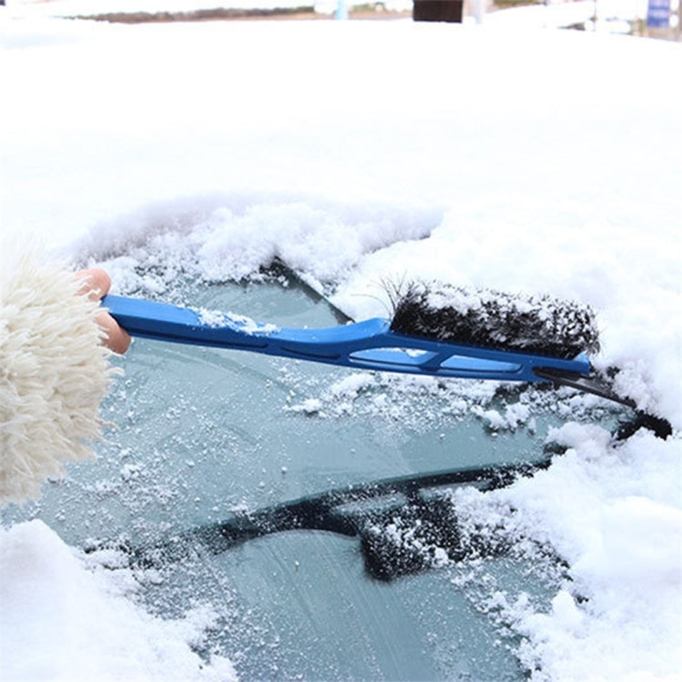 Blue snow brush with scraper blade removing ice and snow from car windshield