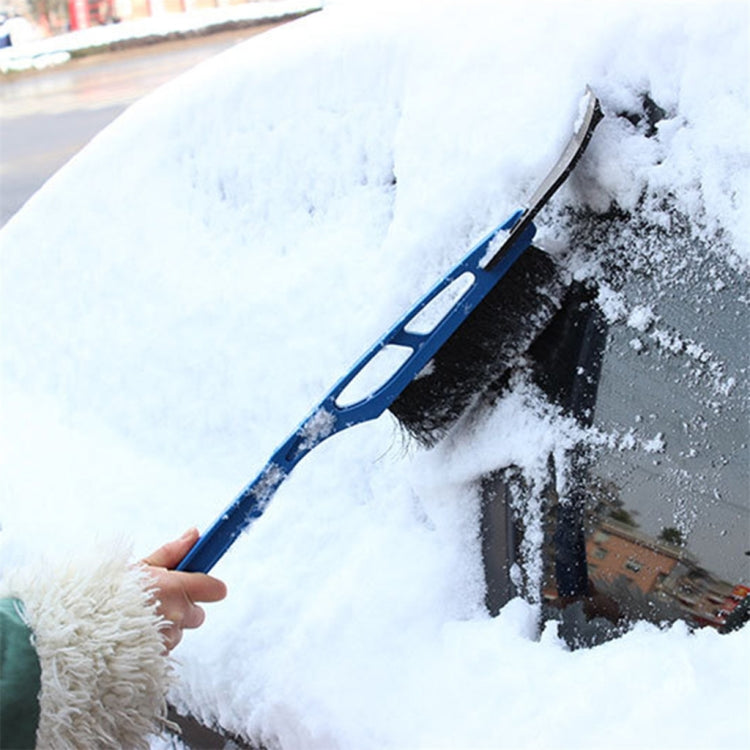 Blue windshield snow scraper brush in use on frosted glass