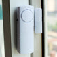 Wireless door/window alarm sensor mounted on door frame, white with circular button