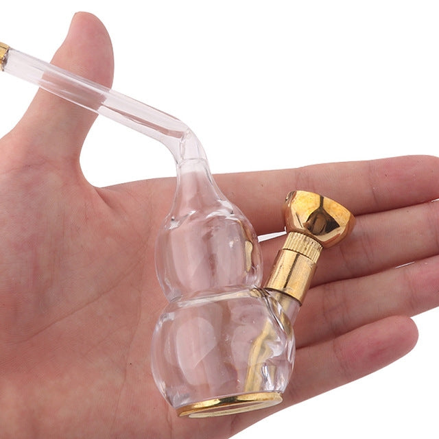 Mini acrylic hookah held in hand, clear chamber and copper-toned valve