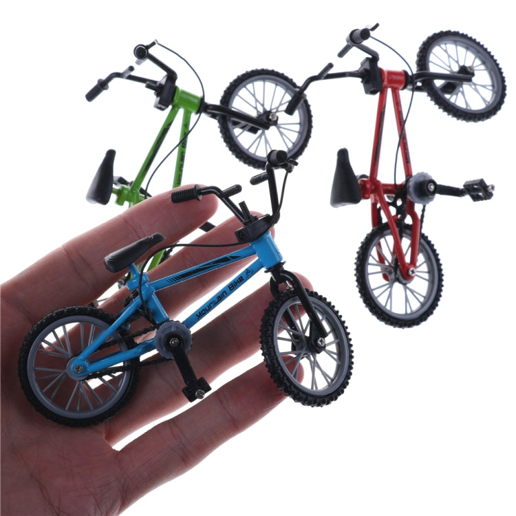 Hand holding mini alloy finger bike toy set, blue and green bikes visible