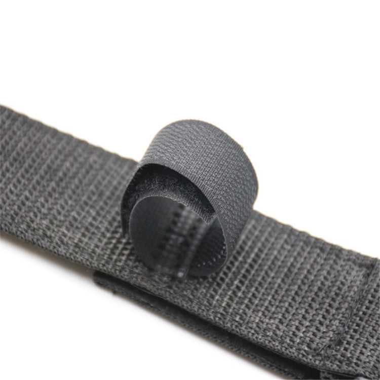 Gray fabric strap end pad with textured surface and hook-and-loop underside