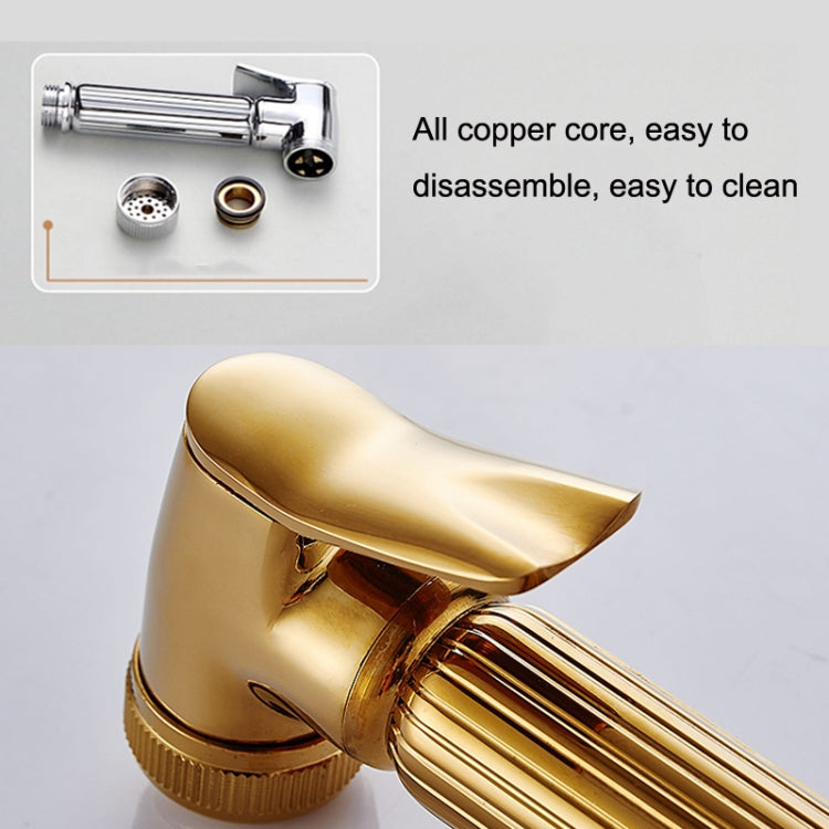 Gold handheld pressure-washer nozzle with water-stop, close-up with inner copper core inset