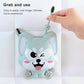 Blue cartoon dog suction toothbrush holder being pressed onto a white tiled wall.