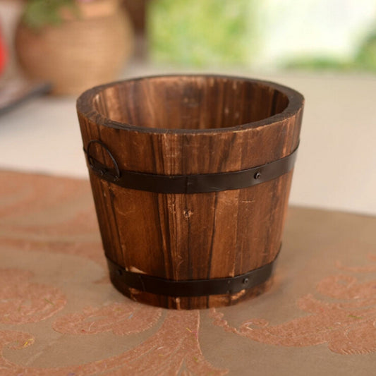 Carbonized wood flower pot: close-up of slatted wooden bucket with dark strap band