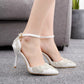 White pointed-toe stiletto heels featuring rhinestone trim along the vamp and ankle strap