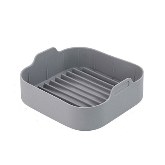 Gray square silicone grill pan insert with ridged lines and handle tabs