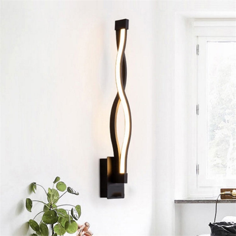 Black LED wall sconce with curved light strip and vertical open-frame shape