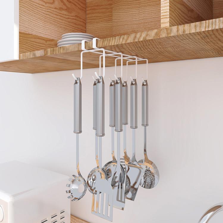White hanging rack with hooks holding ladles, spoons, and other kitchen utensils