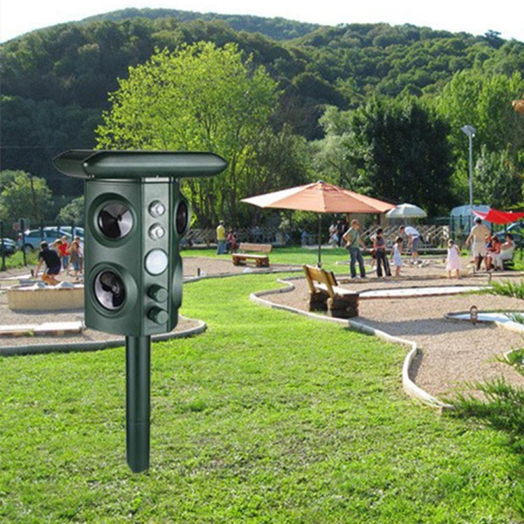 Green solar animal repeller device with three speaker cones on a ground stake