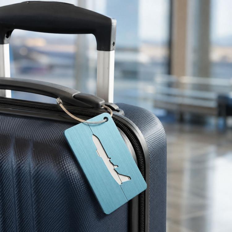Light blue brush aluminum luggage tag with airplane cutout and braided rope loop on suitcase