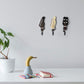 Three small guitar-shaped wall hooks in black and cream, each with curved iron hook