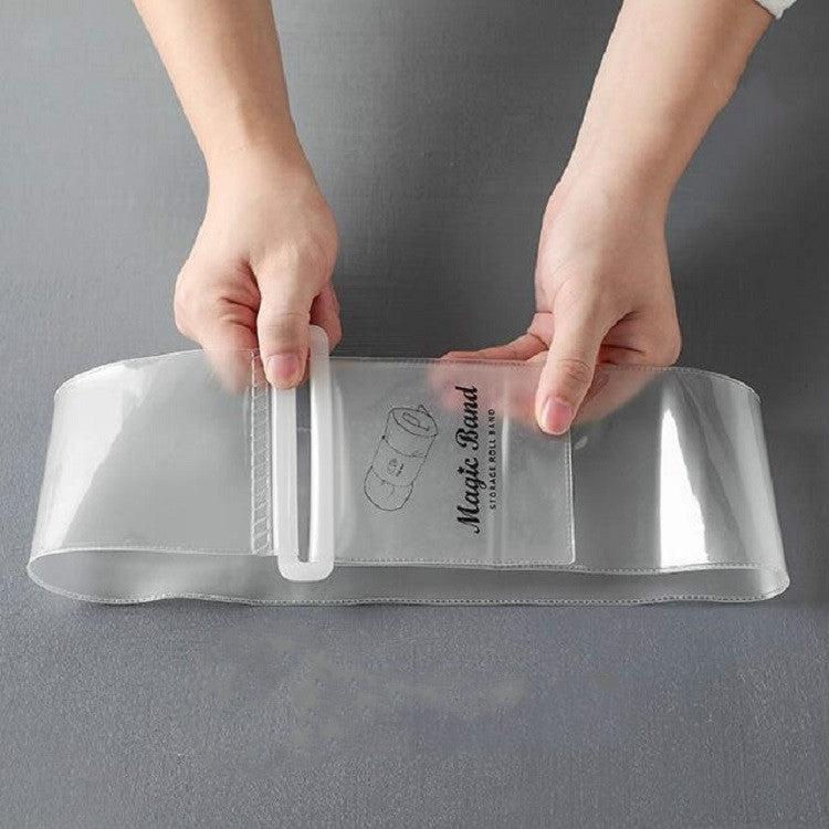 Self-adhesive strap being wrapped around a rolled garment bundle