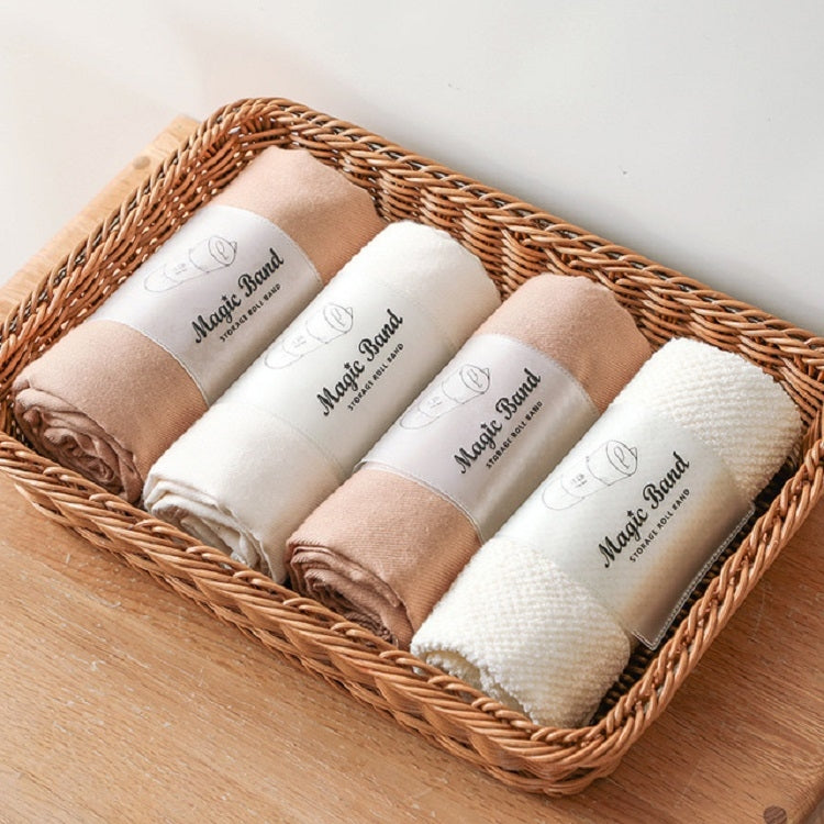 Assorted roll straps in a basket, cream and tan rolled fabric bundles