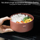 Round insulated heated lunch box holding rice and vegetables inside