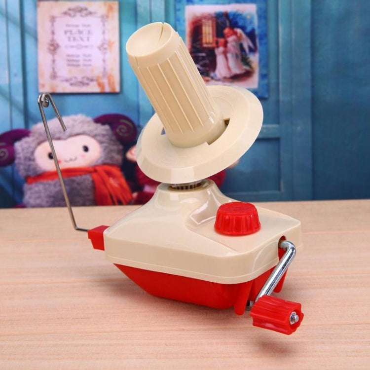 Handheld yarn winding machine with beige spool arm, red knob, and metal handle