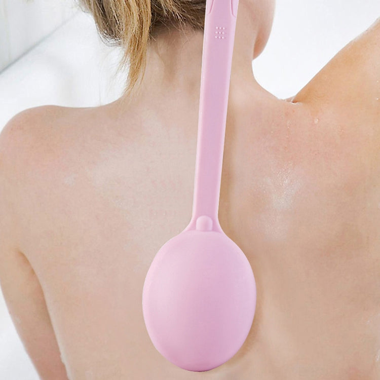 Pink bath brush with soft round head held against skin for body scrubbing