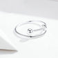 Silver open ring with a round bezel and hinged bar, shown from the side