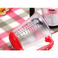 Close-up of measurement markings on a red electronic measuring cup scale