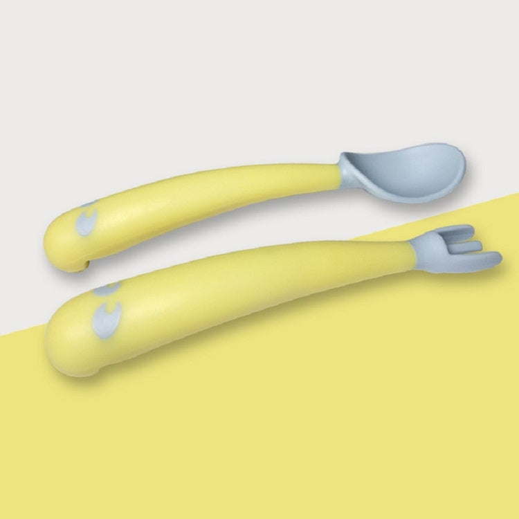 Baby learning yellow curved spoon and fork, dual-piece set