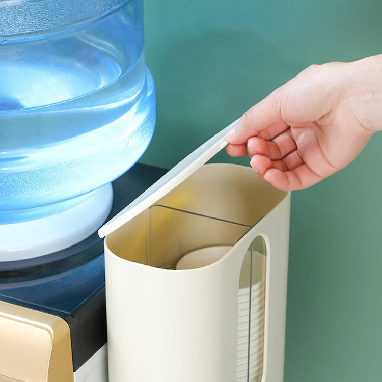 Wall-mounted cup dispenser with open inner tray, hand pulling out the dispensing holder