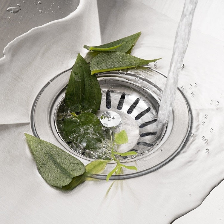 Stainless steel washbasin filter cover in sink drain, with water and leaves