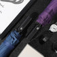 Purple and blue folded umbrellas showing black handles and fabric strap ties